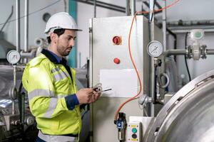 Engineers or utility staff wearing safety helmet fix the machines in the production line. Utility inspector check machine and test the system to meet the standard. machine, Preventive Maintenance photo