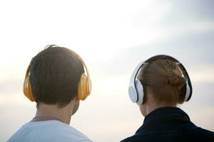 joven personas en auriculares disfrutando música al aire libre foto