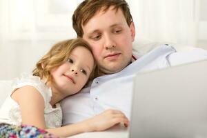 Father and little daughter using laptop photo