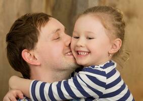 Happy father kissing little daughter photo