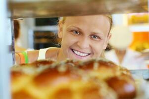 Happy woman looking at fresh bread in the shop photo