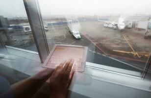 mujer trabajando con tableta ordenador personal en aeropuerto terminal foto