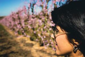 woman among the pretty pink peach tree flowers. photo