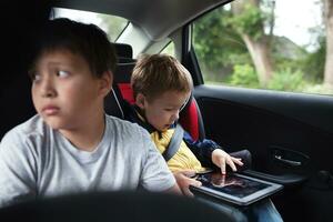 dos Niños de viaje en el espalda asiento de un coche foto