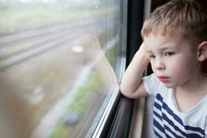 Boy looking out the window of train photo