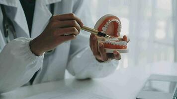 dentistas estão discutindo problemas dentários na imagem de raio-x do relatório na tela do laptop para os pacientes. video