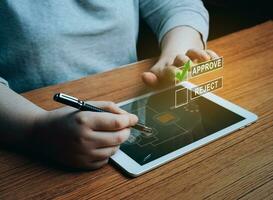 Woman writing or tick correct mark to approve document or project on digital tablet. Evaluation form, questionnaire, acceptance, approval, signing. photo