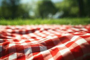 rojo y blanco tartán picnic cobija en parte superior de un verde campo en soleado día en césped de césped en verano parque. borroso antecedentes. generativo ai foto