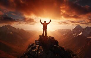 The silhouette of a tourist standing with his arms outstretched the golden glow of the morning sun on the mountaintop. Standing up to achieve success. photo