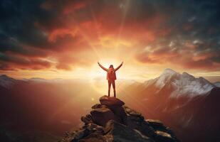 The silhouette of a tourist standing with his arms outstretched the golden glow of the morning sun on the mountaintop. Standing up to achieve success. photo