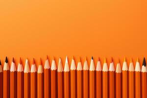 Colored pencils on orange background photo