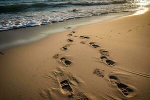 Footprints in the sand at sunset on a beautiful beach photo