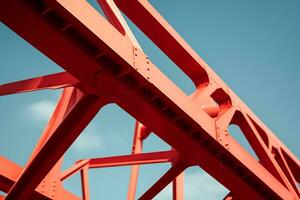 Low angle of a metal red structure under the clear blue sky photo