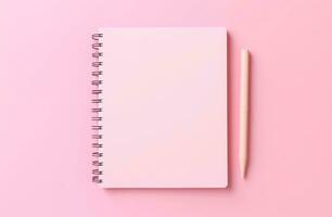 Notepad with blank pages and pen on a pink background. photo