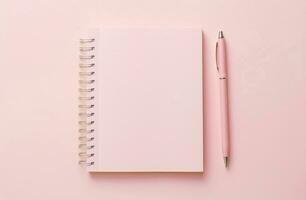 Notepad with blank pages and pen on a pink background. photo