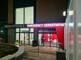 Low Angle Illuminated View of Emergency Entrance of Luton and Dunstable Hospital at Luton City of England UK During Midnight of Sep 3rd, 2023. Hospital's Building is Under construction for Renovation photo