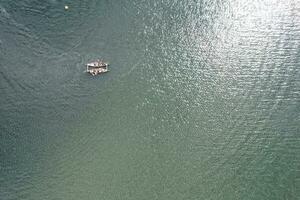 alto ángulo imágenes de personas son paseo en barco a caldecotta lago situado a milton Keynes ciudad de Inglaterra genial Bretaña Reino Unido. el aéreo paisaje estaba capturado en agosto 21, 2023 con drones cámara foto