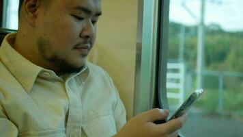 A man in a commuter train subway metro traveling and uses the smartphone happy tourist travel by train  Freedom trip on vacation time holiday weekend video