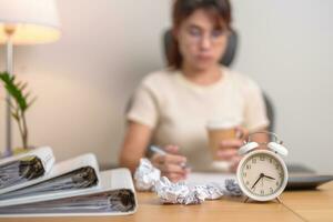stressed Woman with mistake paper and clock, Tired female businesswoman working overload at office, Exhausted woman with document folder stack at late night in home. Failure, Problem and business photo