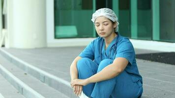 Upset nurse sitting on floor in hospital ward video