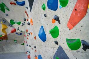 Bouldering gym with artificial colourful rock wall photo