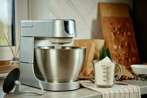 Electric mixer kneads dough in the kitchen photo