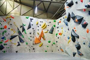 Bouldering gym with artificial colourful rock wall photo