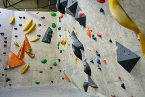 Bouldering gym with artificial colourful rock wall photo