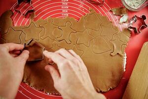 Process of woman making gingerbread cookies at home photo