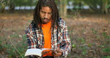 auténtico imágenes de inteligente joven negro hombre leyendo video