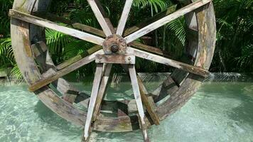 A retro, round wooden turbine spins to oxygenate the pond in front of the house. video
