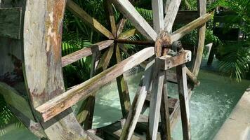 un retro, redondo de madera turbina giros a oxigenar el estanque en frente de el casa. video