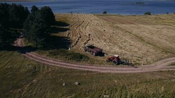 Haut vue de une tracteur collecte foins dans foins saison sur tondu Prairie video