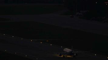 sotsji, Rusland juli 29, 2022 - vliegtuig nemen uit Bij nacht Bij adler luchthaven. landingsbaan verlichting met landen lichten. video