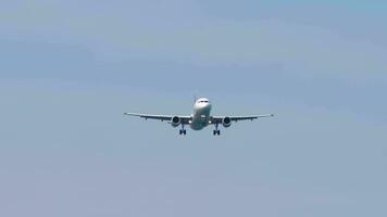 Front view of unrecognizable passenger airliner approaching landing. Airplane in the blue sky, sunny day. Footage of aircraft flies. Tourism and travel concept video