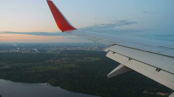 Aussicht durch das Bullauge auf ein schön Sonnenuntergang oder Dämmerung Himmel. pov Flugzeug Landung, Aussicht von das Wolken und das Stadt video