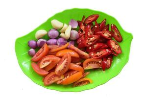 Typical Indonesian kitchen spices consist of pieces tomatoes, onion, garlic, and chilies isolated on white background photo