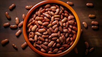 Top view of assorted beans in a wooden bowl on a wooden table photo