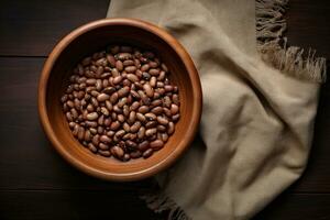 Top view of assorted beans in a wooden bowl on a wooden table photo