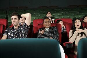 Various people in theater. Multiracial audiences, Black woman, and friends watching dramatic cinema and sad emotional expressions together on movie shows ending, entertainment lifestyle with film. photo