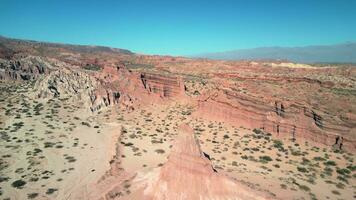 aérien vue drone en volant plus de scénique rouge rocheux montagnes et aride désert paysage avec une clair bleu ciel. video