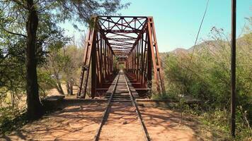 Aerial view drone crossing over old bridge with rails. video