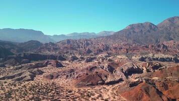 aérien vue drone en volant plus de scénique rouge rocheux montagnes paysage avec une clair bleu ciel. video