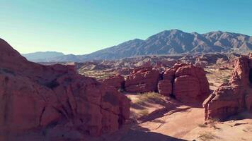 aereo Visualizza fuco volante al di sopra di panoramico rosso roccioso montagne e arido deserto paesaggio con un' chiaro blu cielo. video