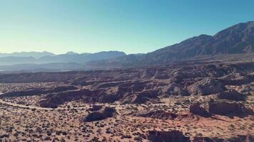 Aerial view drone flying over scenic rocky mountains and arid desert landscape with a clear blue sky. video