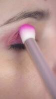 Woman Puting Pink Eye Make up on Pink Background video