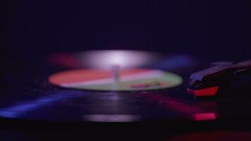 vicino su di un' vinile disco giocatore Filatura con cinematico rosso e blu illuminazione video