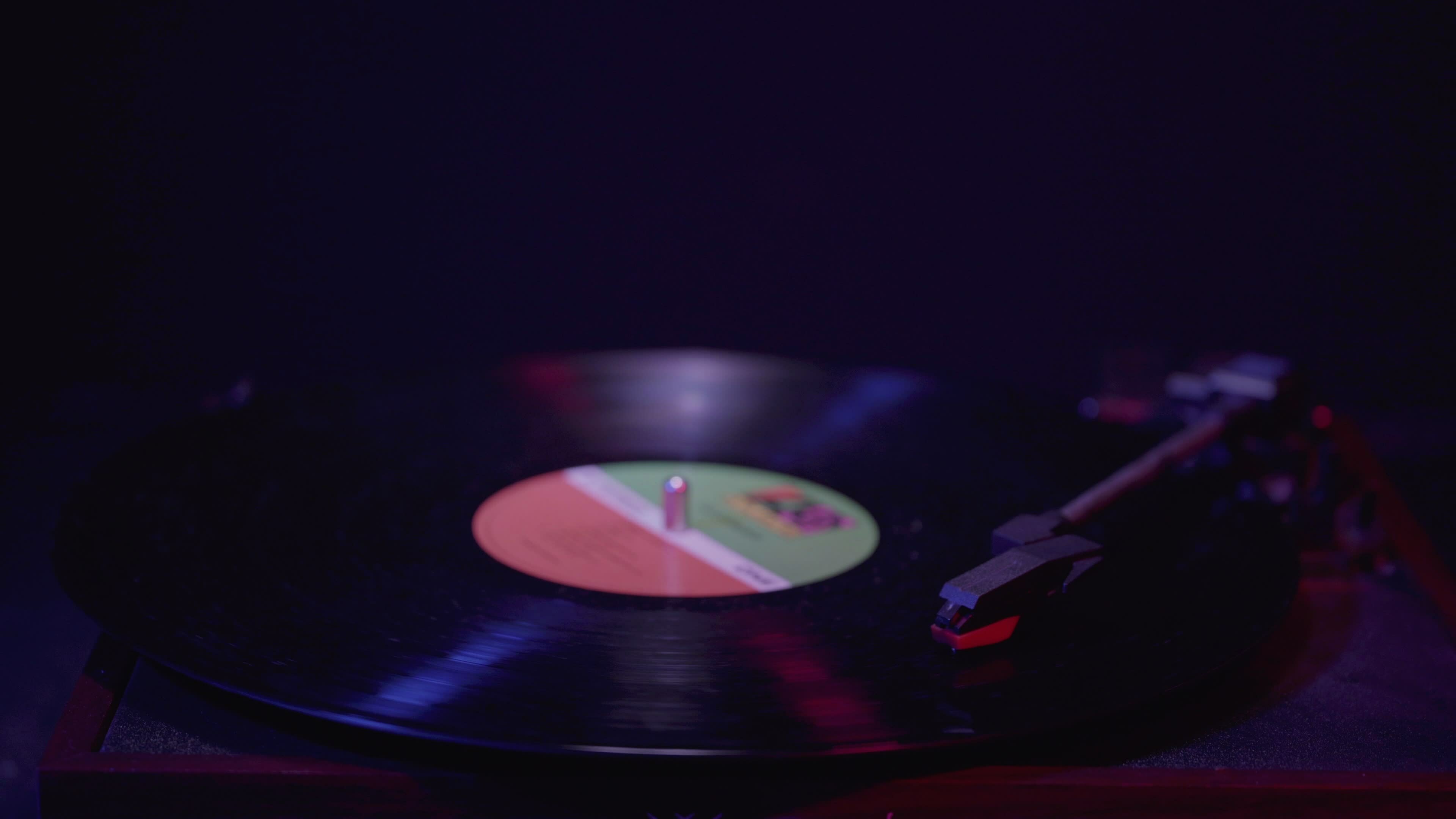 Close up of a Vinyl Record player Spinning with cinematic red and blue