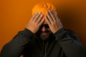 a man with a orange knitted hat is laughing on background photo