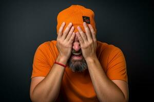 un hombre con un naranja de punto sombrero es riendo en antecedentes foto